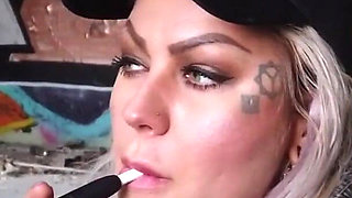 Blonde lady smokes an electronic cigarette on stair
