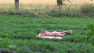 A cute cutie publicly sunbathes in the open air completely naked.