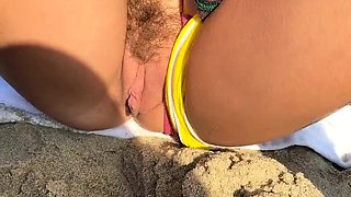 Naughty teen showing off her pussy and peeing on the beach