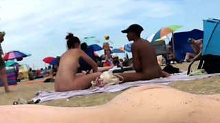 Un homme sur une plage naturiste ejacule