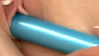 Brunette and blonde lesbians playing with a sex toy