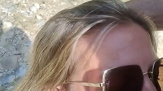 She sucks him at the water's edge